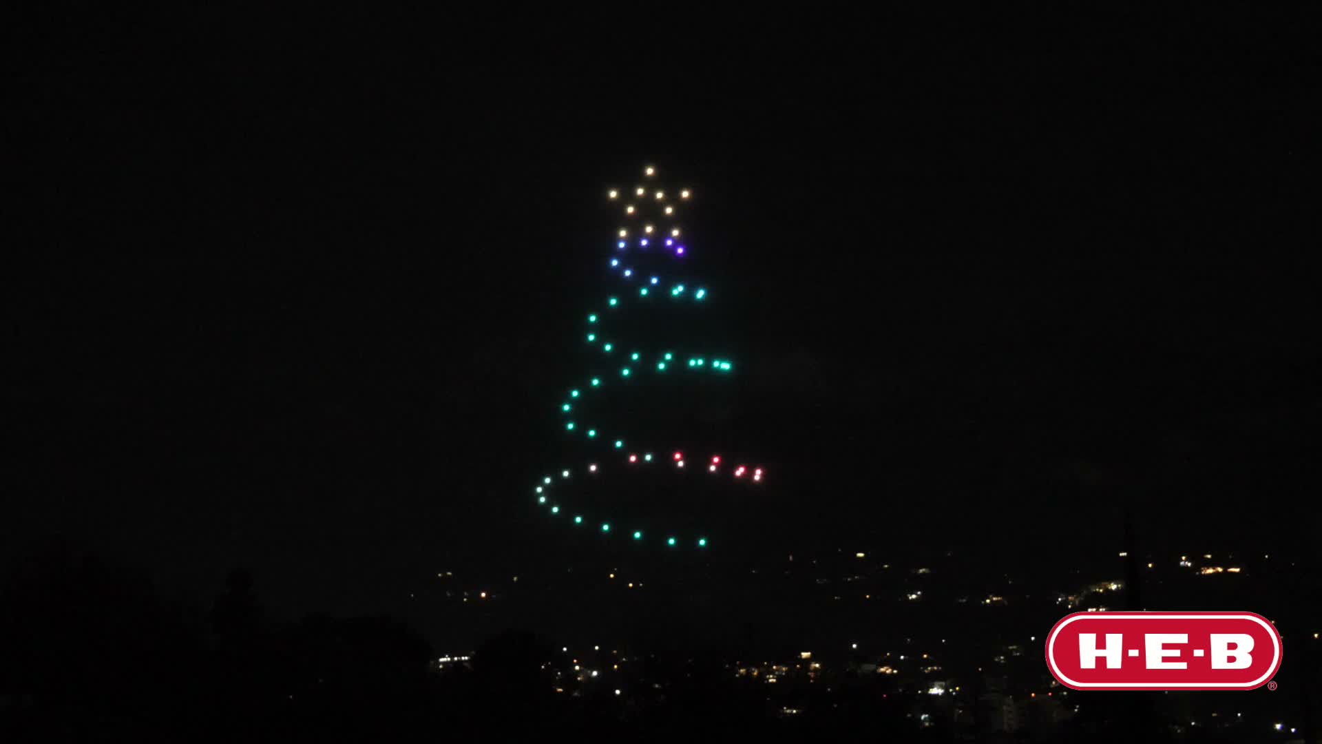 Swarm of light drones forming a figure over a night event
