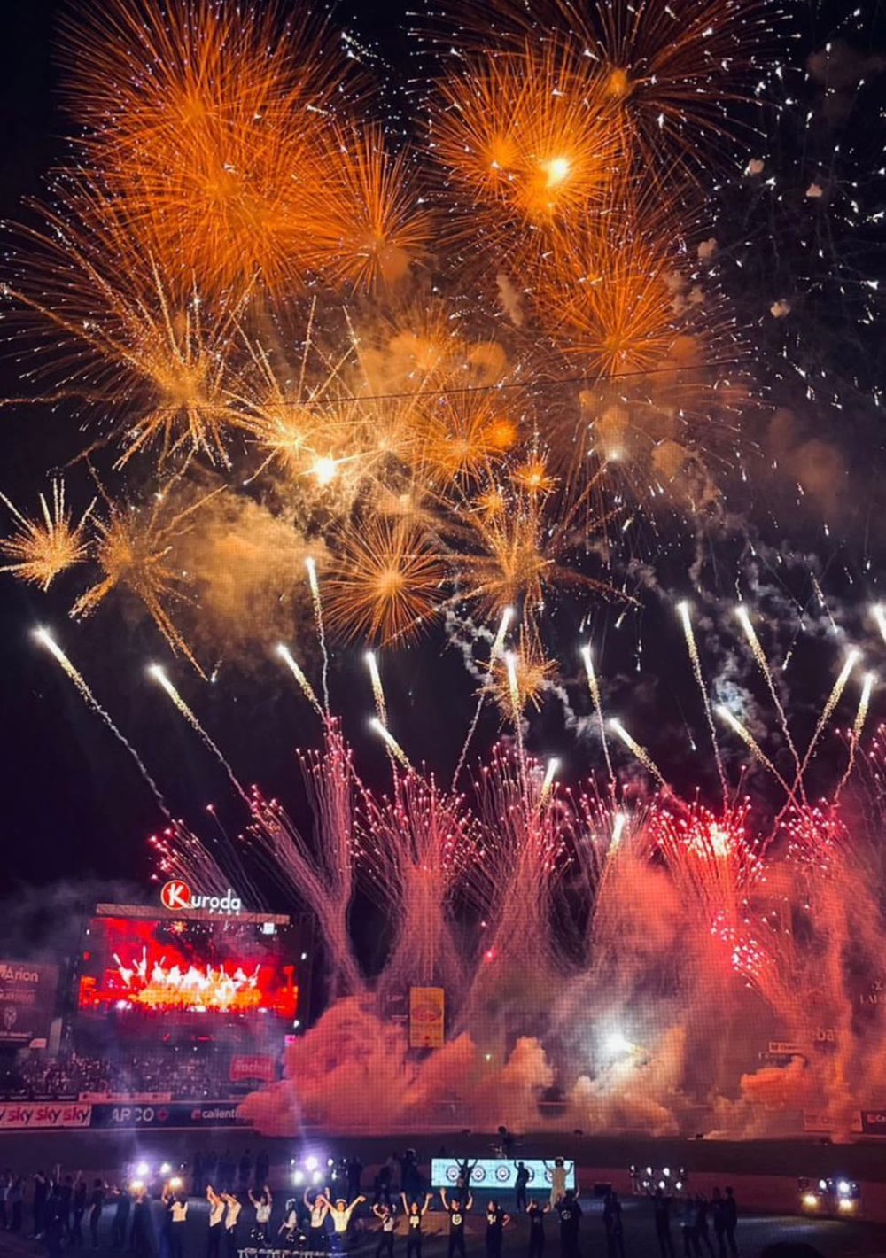 Aerial and ground pyrotechnics during an opening ceremony in a packed stadium