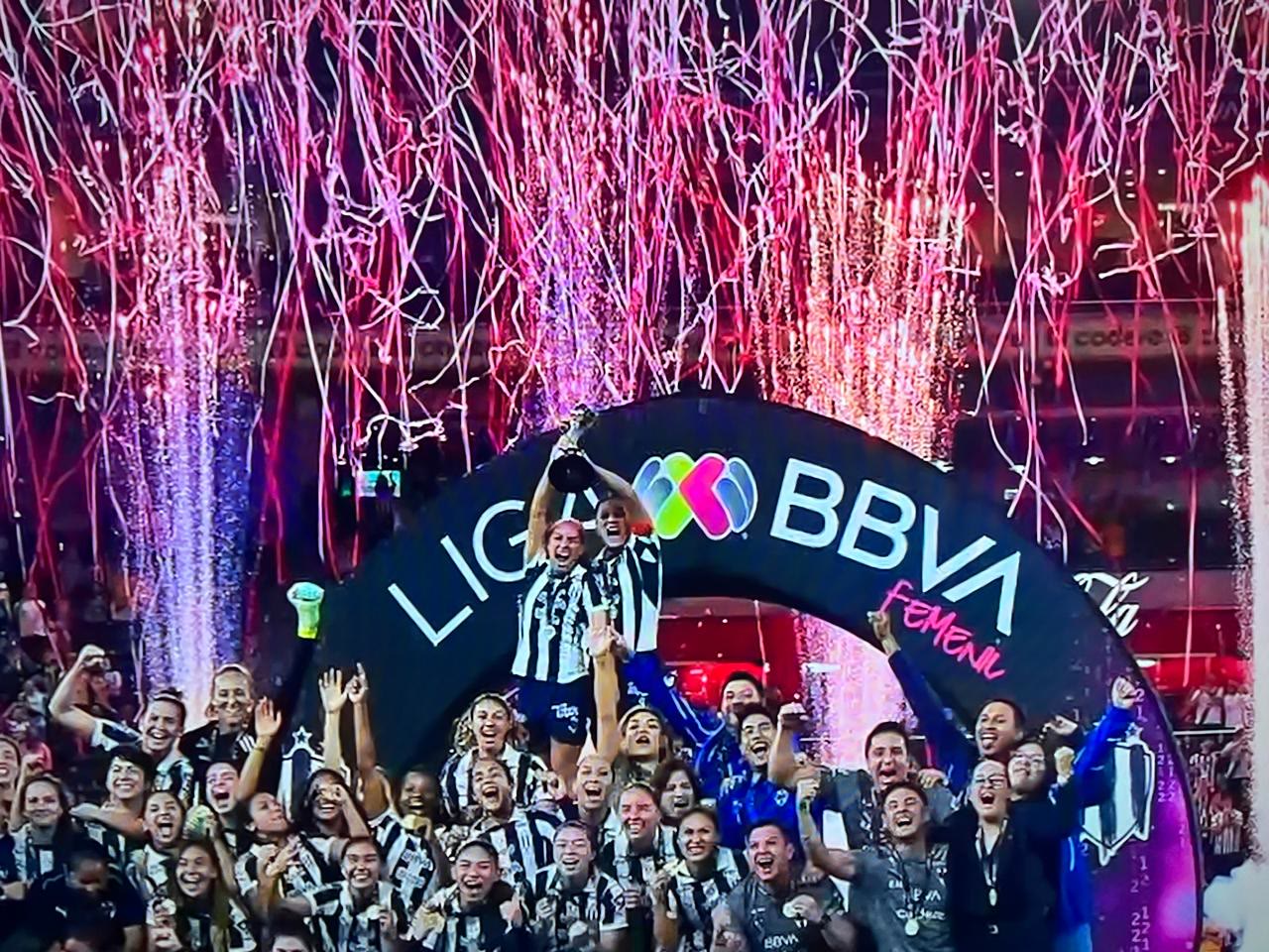 Serpentina y confeti cayendo sobre el equipo campeón mientras levanta el trofeo