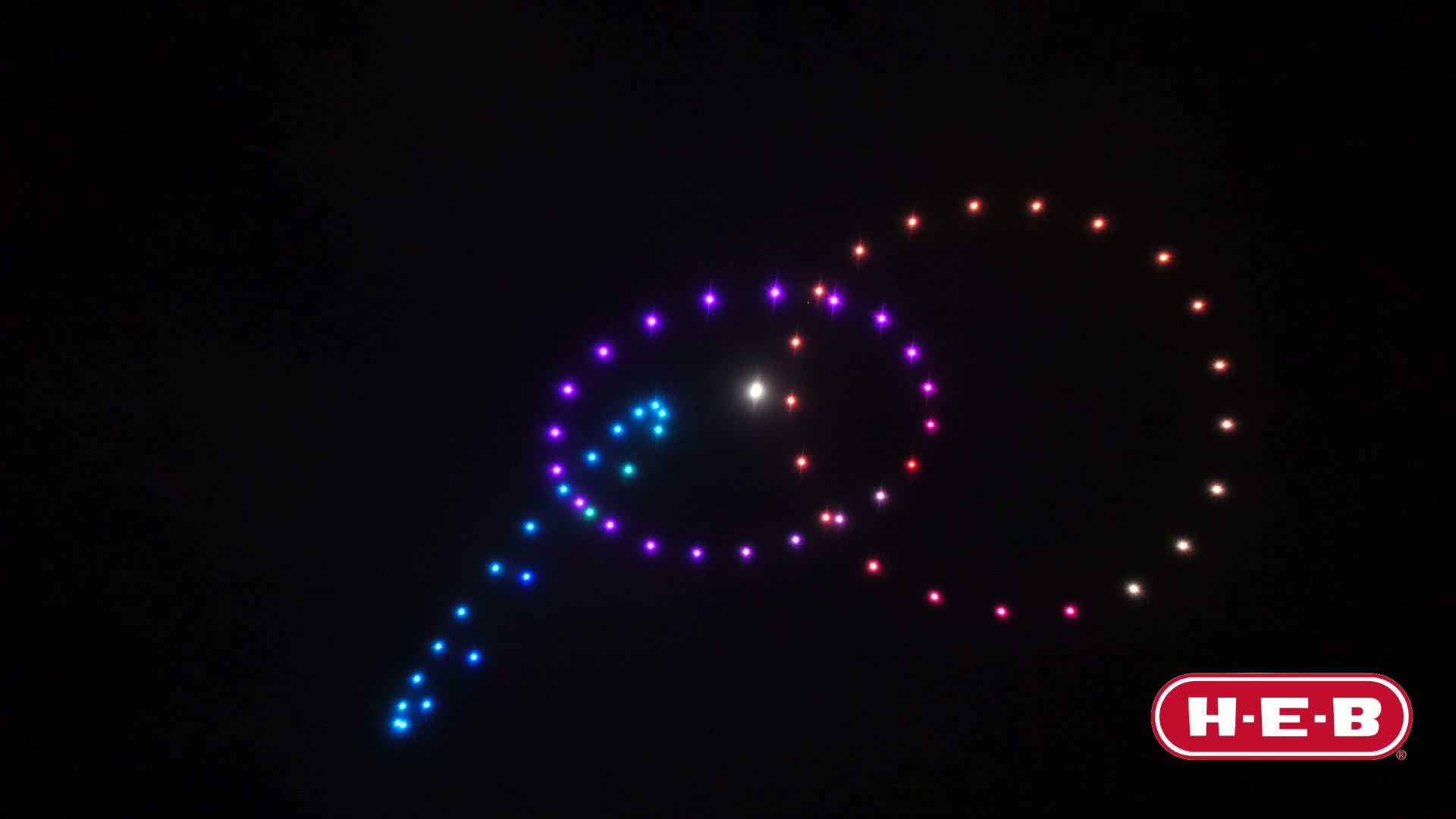 Swarm of light drones forming a figure in the night sky
