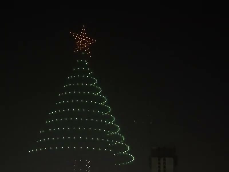 Enjambre de drones de luz formando un árbol de Navidad en el cielo nocturno