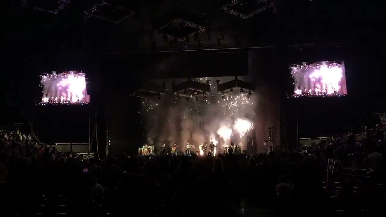 Cortina de chispa fría sobre el escenario durante un concierto con el público de pie
