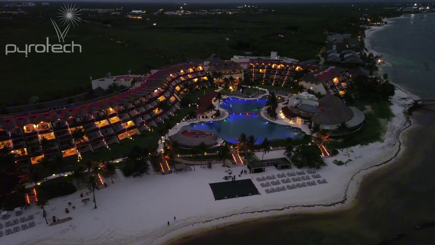 Vista aérea de un resort de playa al anochecer con la parrilla de despegue de drones montada sobre la arena