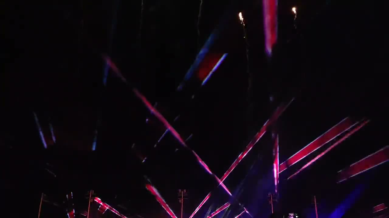 Haces de láser, fuego y pirotecnia combinados sobre un estadio lleno de gente