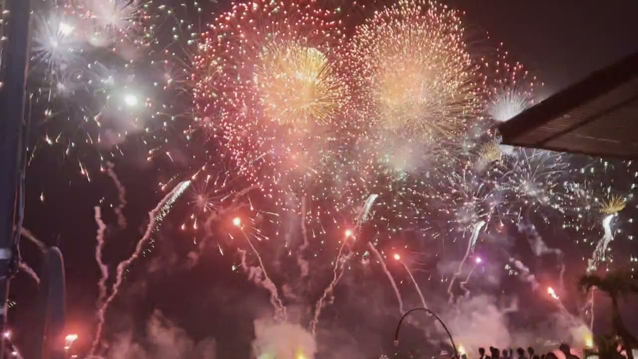 Colored fireworks opening over the audience at a night celebration