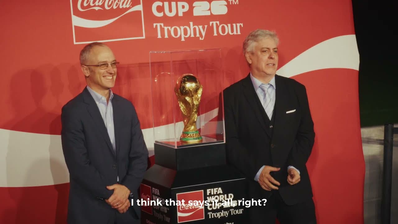 El trofeo original de la Copa Mundial de la FIFA en su vitrina, frente al fondo del Coca-Cola Cup 26 Trophy Tour